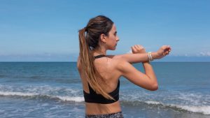 Fit woman stretching on Manzanillo del Mar beach in Colombia with ocean in background